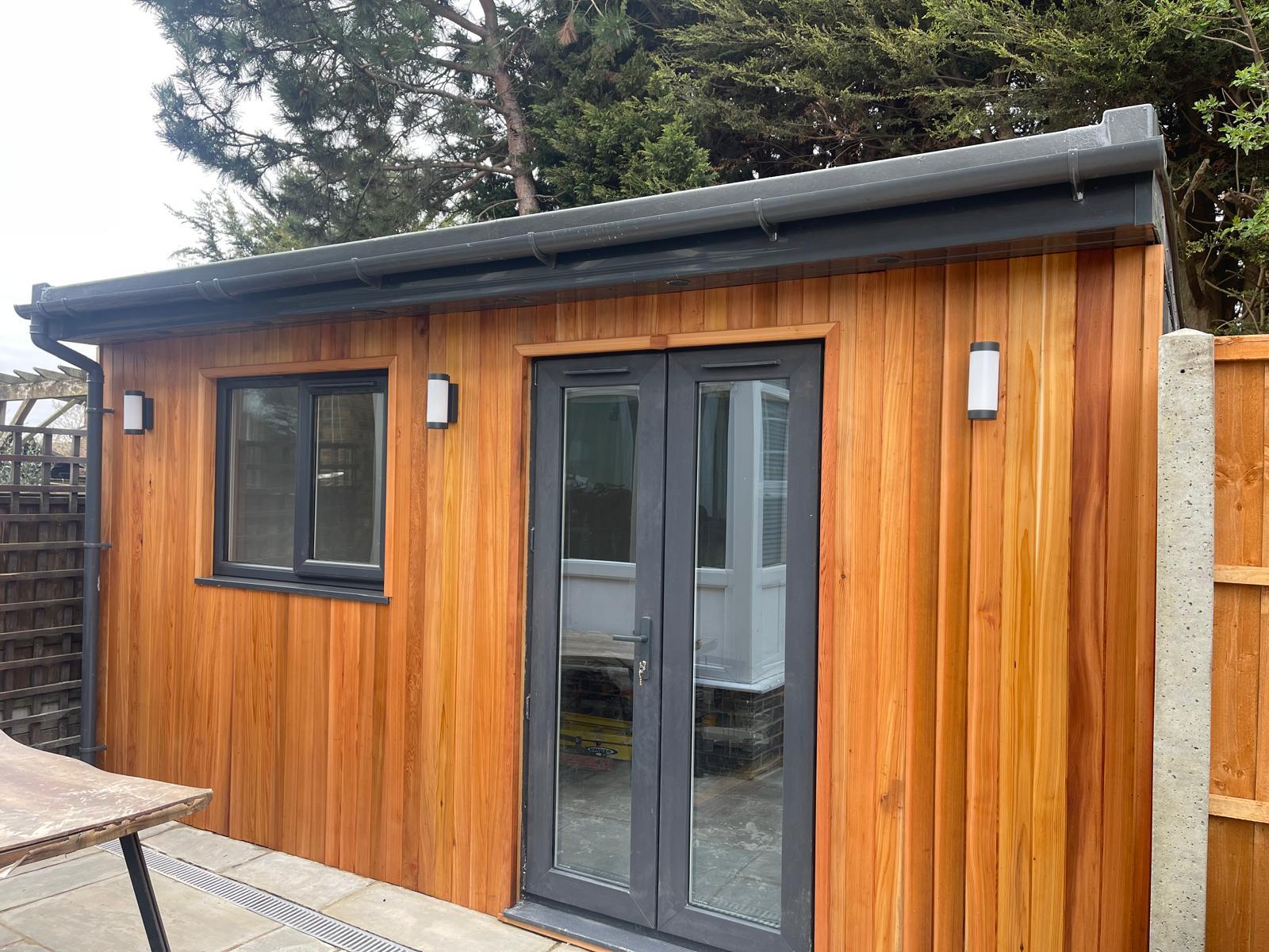 Bespoke cedar-clad garden room with anthracite doors and windows