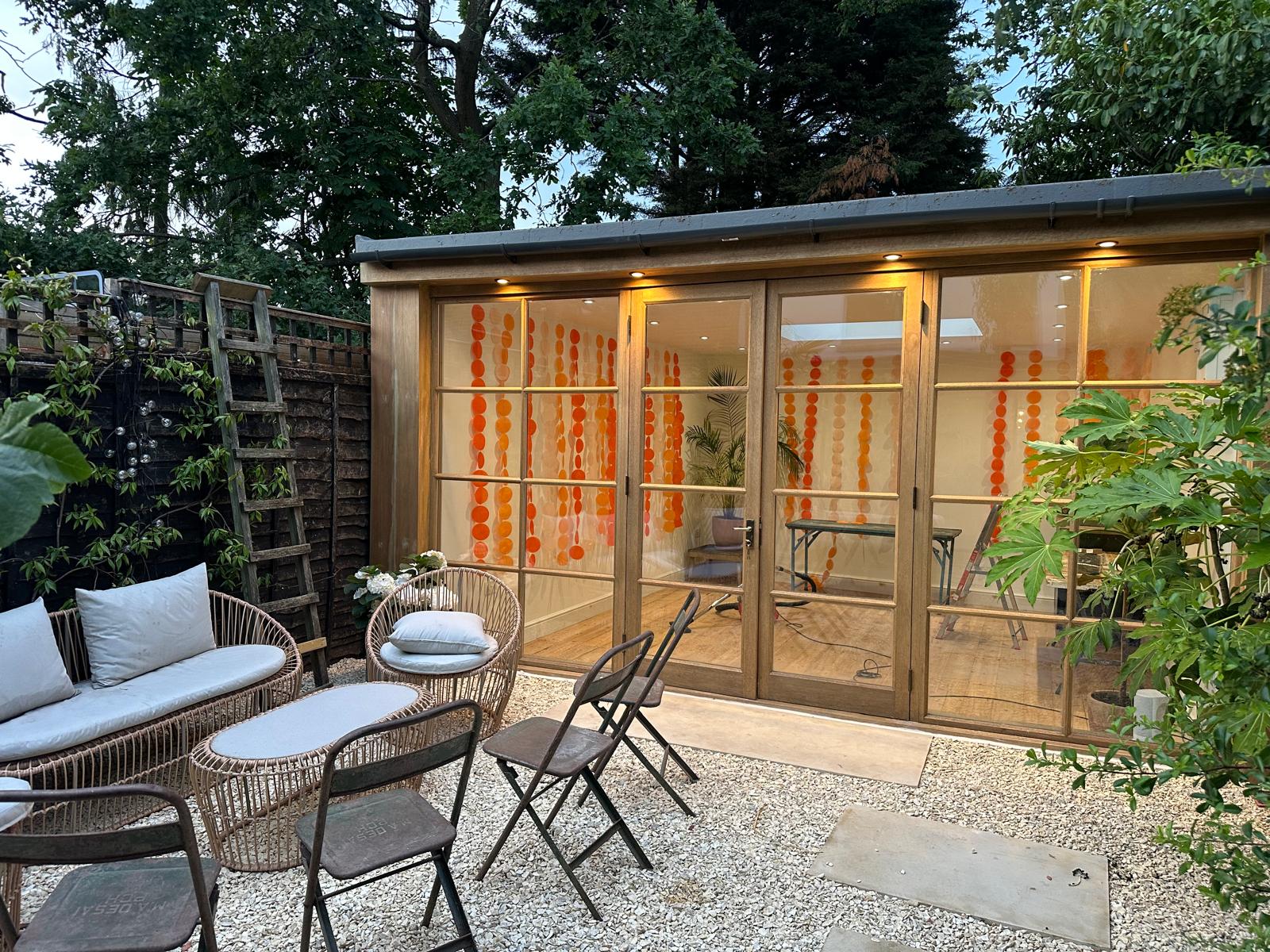 Garden room at dusk with warm interior lighting and glazed bi-fold doors